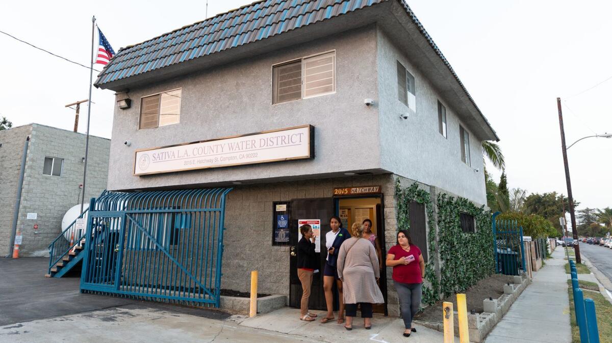 Residents gather outside the door of the Sativa-Los Angeles County Water District office during the special closed-door meeting. They all say they have experienced brown water in their homes.