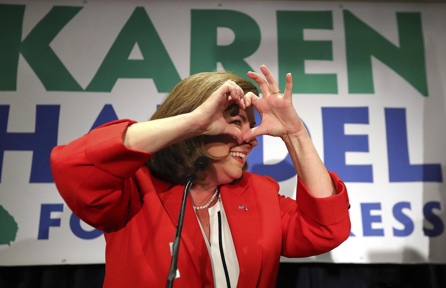 Karen Handel makes a heart symbol while making an early appearance to thank her supporters after the first returns came in during her election night party in the 6th District race with Jon Ossoff on June 20, 2017, in Atlanta.