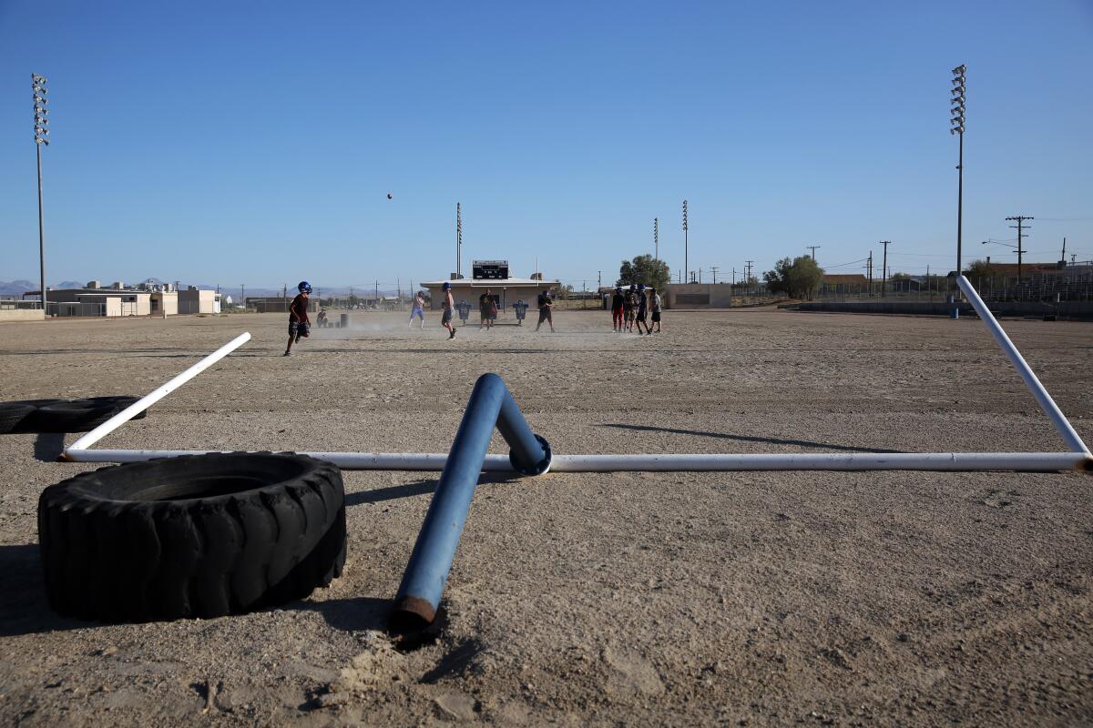 The Trona High football team practices at their school in Trona, Calif. A goal post was knocked to the ground after two earthquakes hit in July near Ridgecrest.