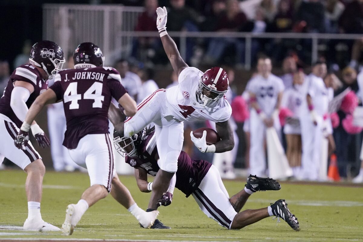 Alabama running back Brian Robinson Jr. (4) is upended by Mississippi State defenders after a short run during the first half of an NCAA college football game in Starkville, Miss., Saturday, Oct. 16, 2021. (AP Photo/Rogelio V. Solis)