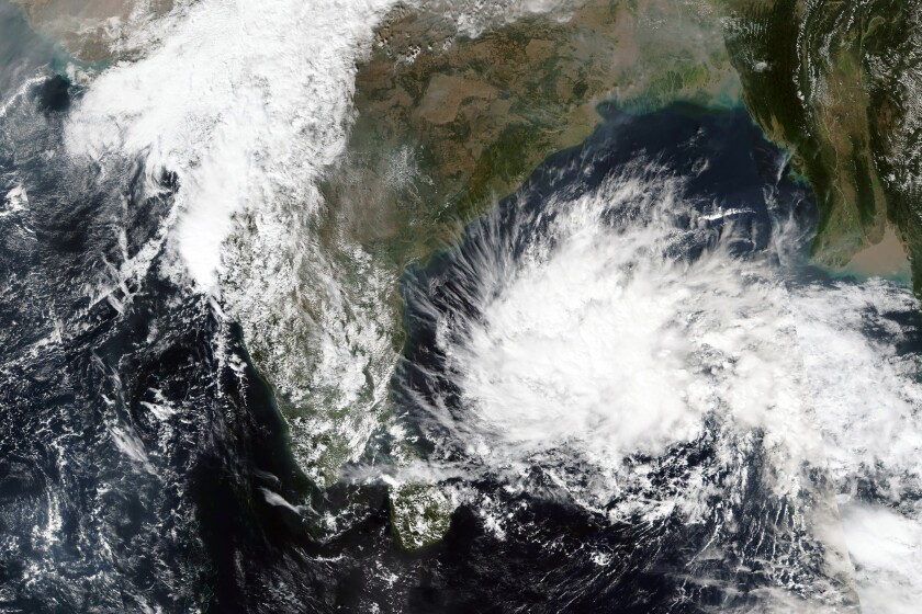 This Thursday, Dec, 2, 2021, satellite image released by NASA shows a storm brewing in the Bay of Bengal. Indian authorities issued an alert, shut schools and canceled trains in parts of the country on Friday, Dec. 3, 2021, as rescue teams braced for the tropical storm to possibly make landfall. (NASA Worldview, Earth Observing System Data and Information System (EOSDIS) via AP)