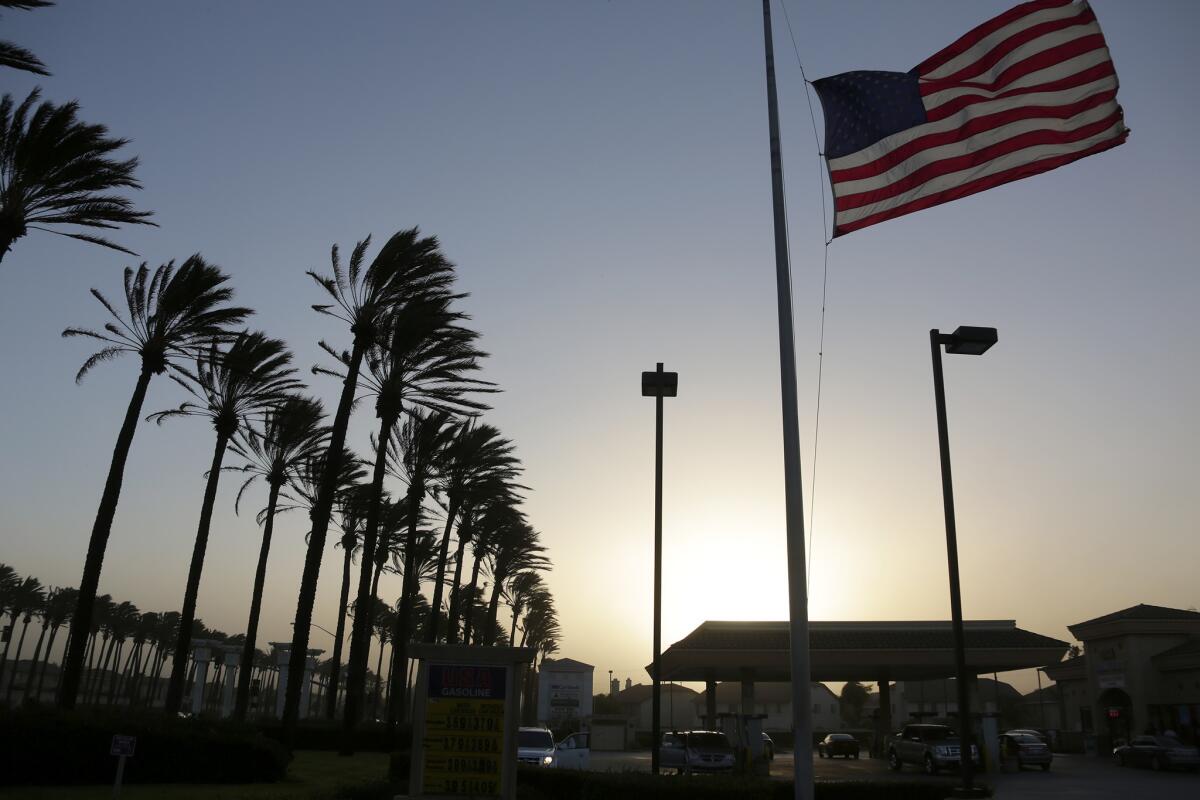 Palm trees sway and a flag flutters in gusty winds in Fontana as Santa Ana winds move into Southern California in 2013.