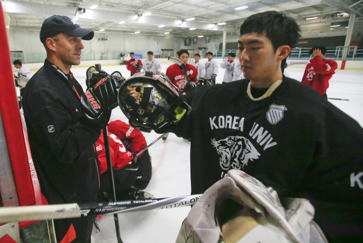 Craig Johnson, a coach in the Ducks youth hockey league system, fist-bumps one of the players from Korea University after practice on July 30.