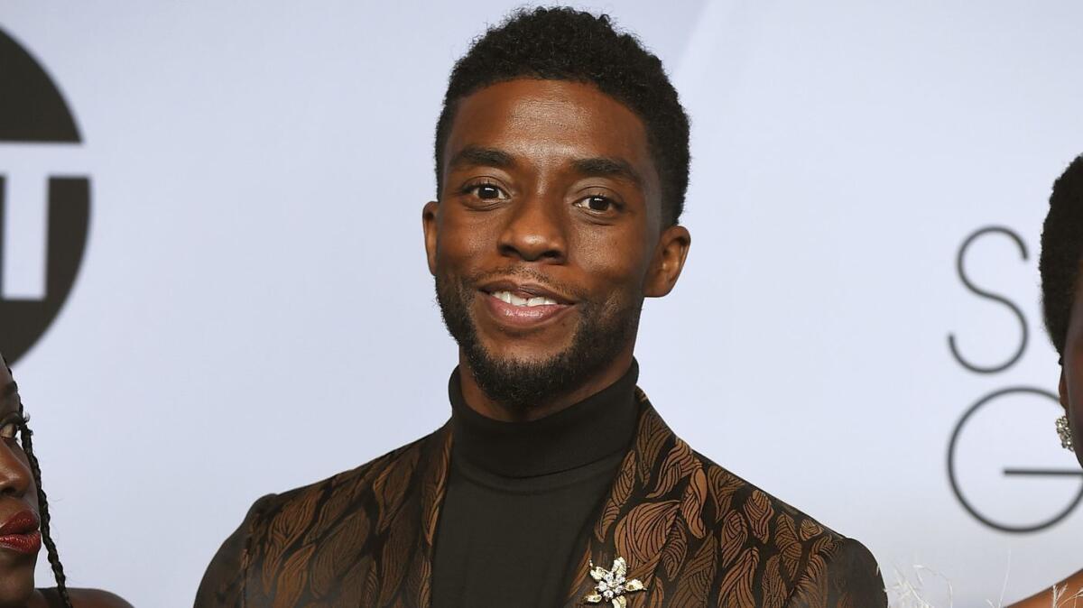 Chadwick Boseman in a turtleneck and suit