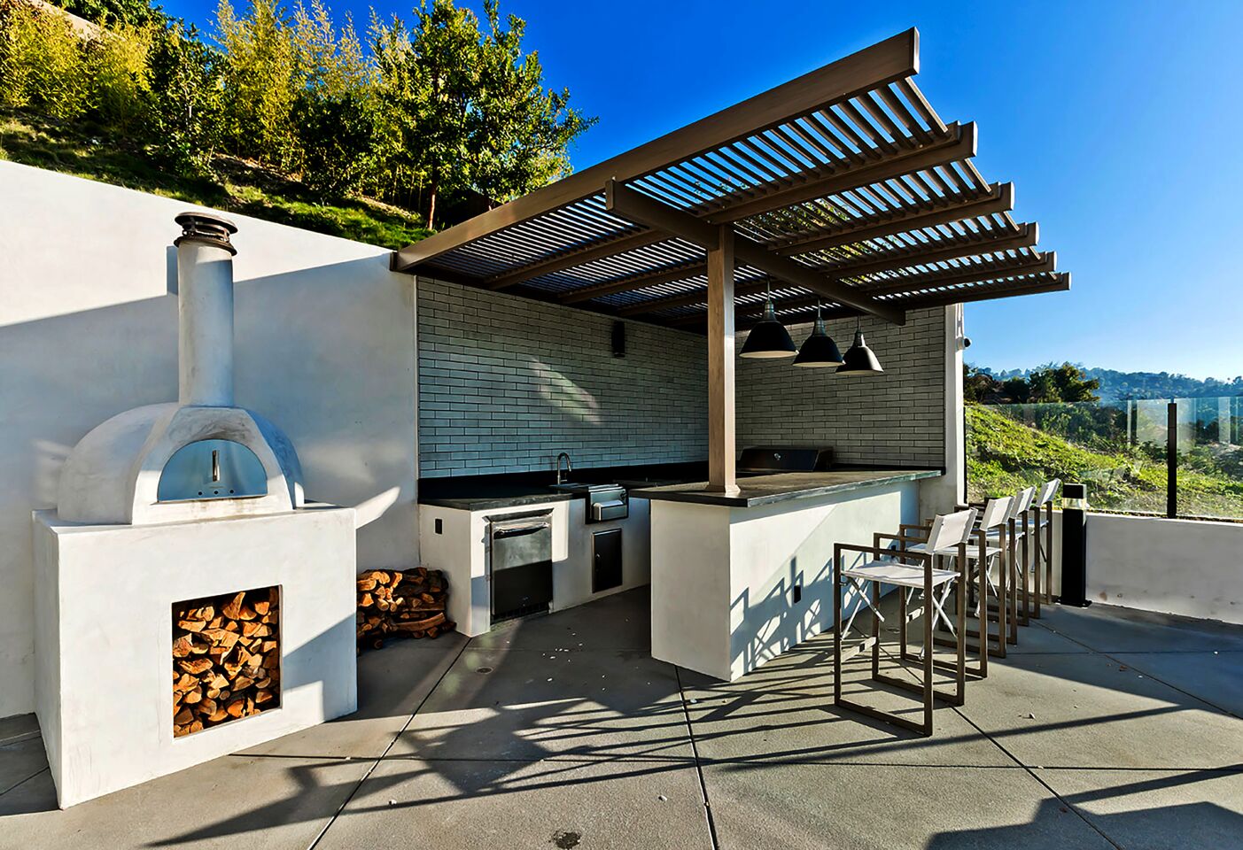 An outdoor kitchen, lounge and fenced play yard make up the grounds.