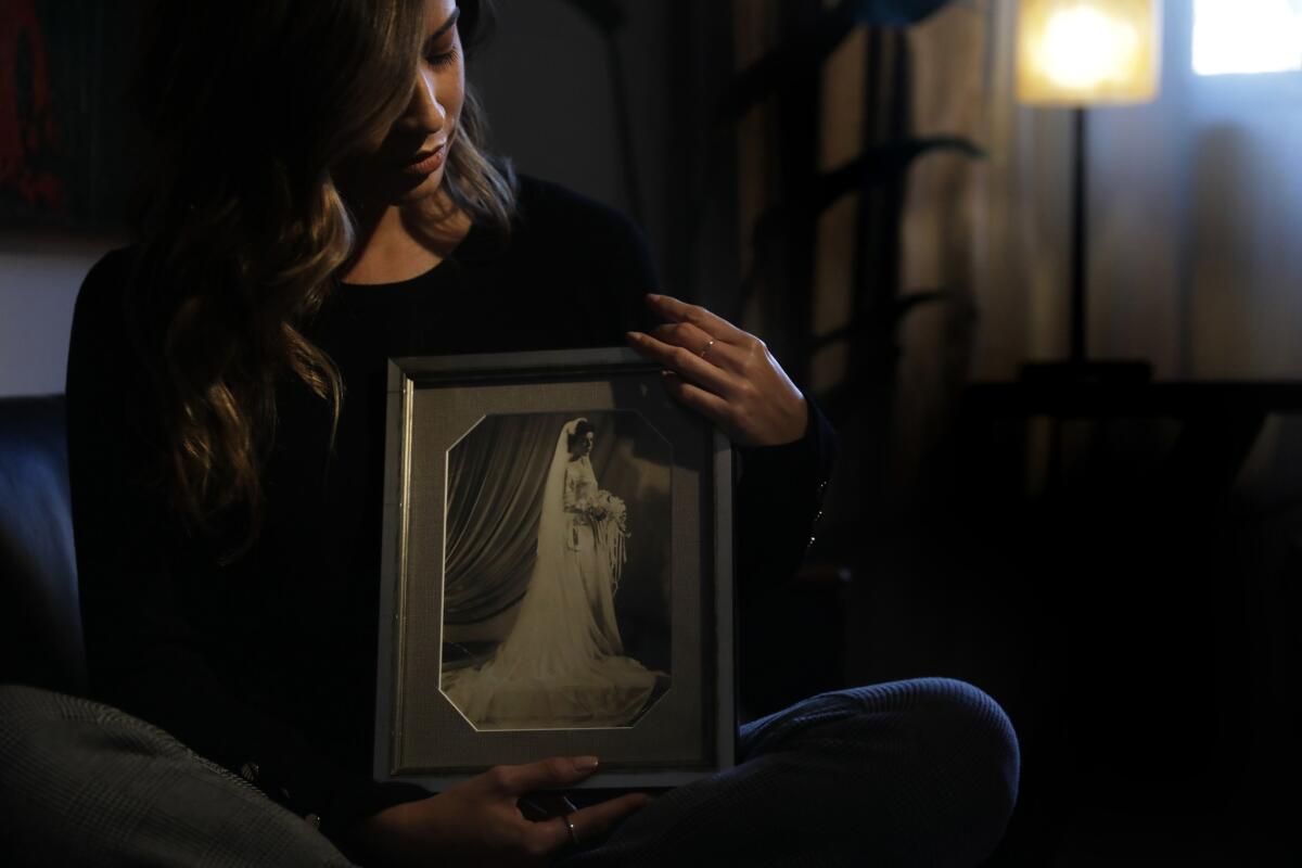 Alejandra Campoverdi with a portrait of her late grandmother, who died from breast cancer. (Christina House / Los Angeles Times)