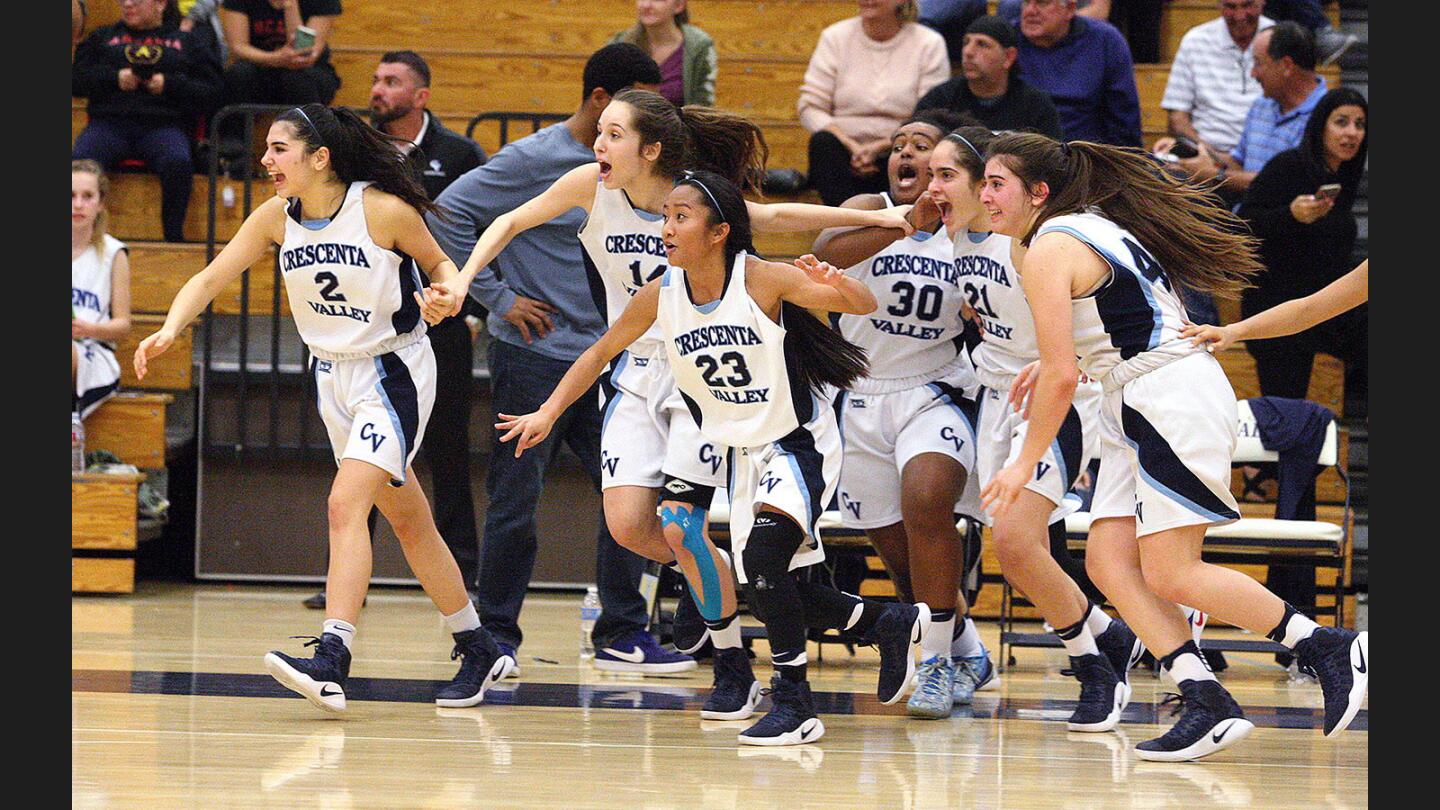 The Crescenta Valley bench, after waiting and doing a false rush onto the floor when they tough time was out, runs this time onto the floor to celebrate winning the Pacific League title over Arcadia girls' basketball game at Crescenta Valley High School in La Crescenta on Thursday, February 9, 2017.