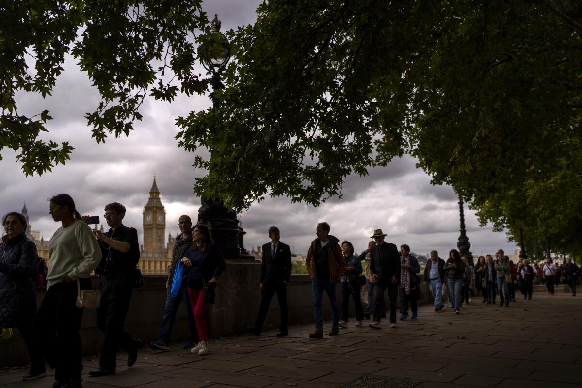 FILE - People queue to pay their respect to the late Queen Elizabeth II while she lies in state outside Westminster Hall in London, Sept. 15, 2022. (AP Photo/Emilio Morenatti, File)