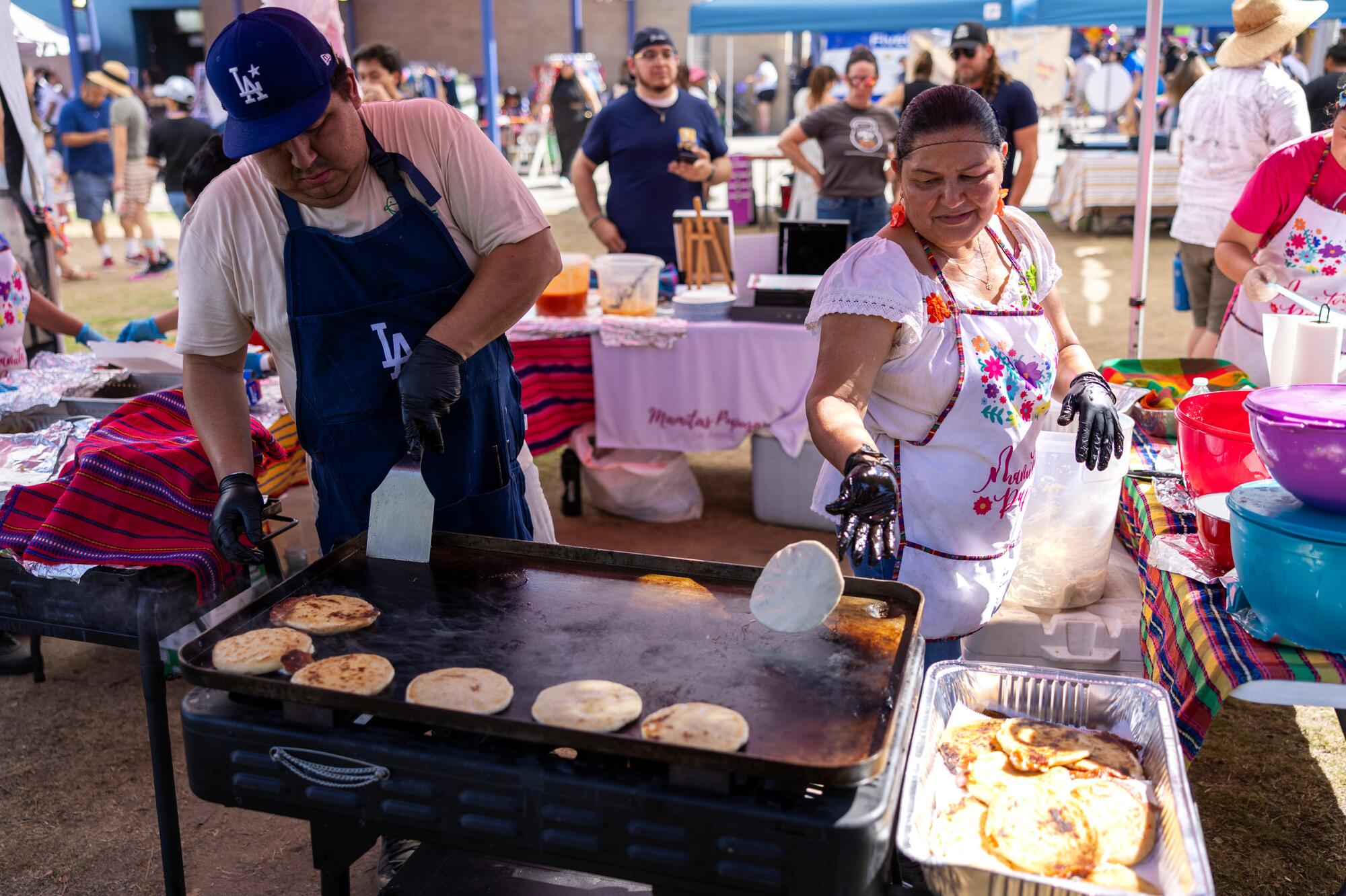 The owners of Mamita's Pupusas prepare the Salvadoran dish for Púchica Fest event-goers 