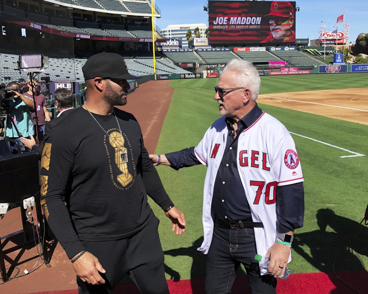 Los Angeles Angels first baseman Albert Pujols, left, speaks with new manager Joe Maddon after a baseball news conference at Angel Stadium