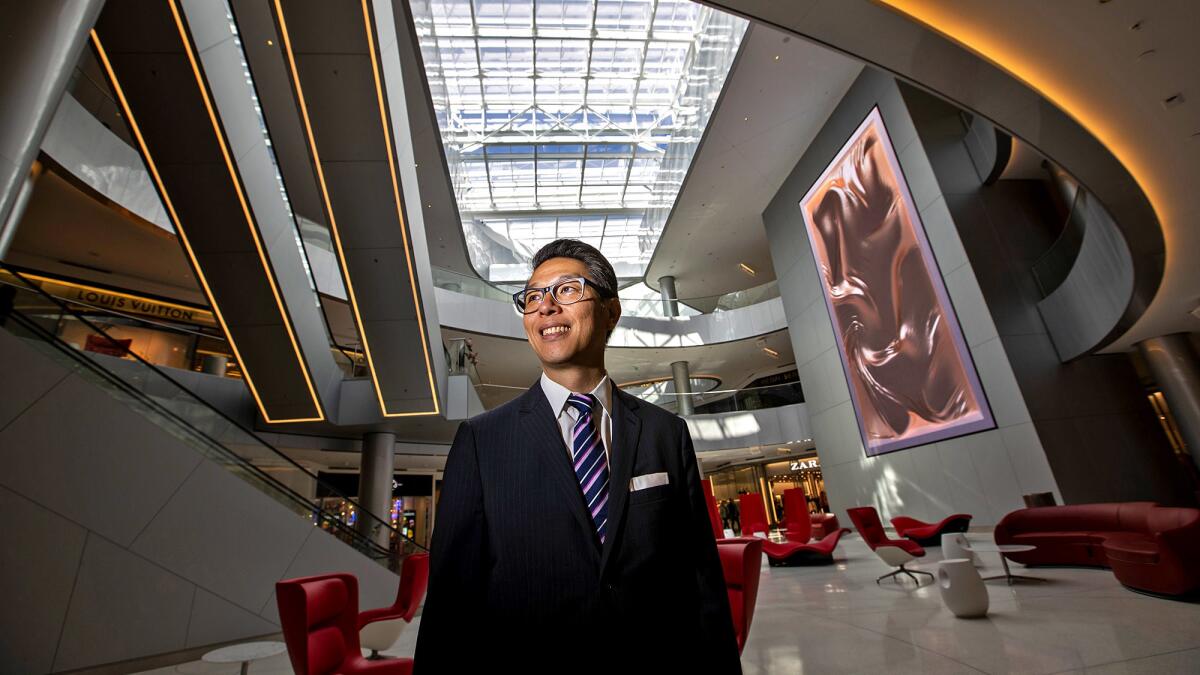 Ralph Barnes, general manager of the Beverly Center, next to artist Refik Anadol's "Chapter 1: Impossible Materials" hanging in the main court.