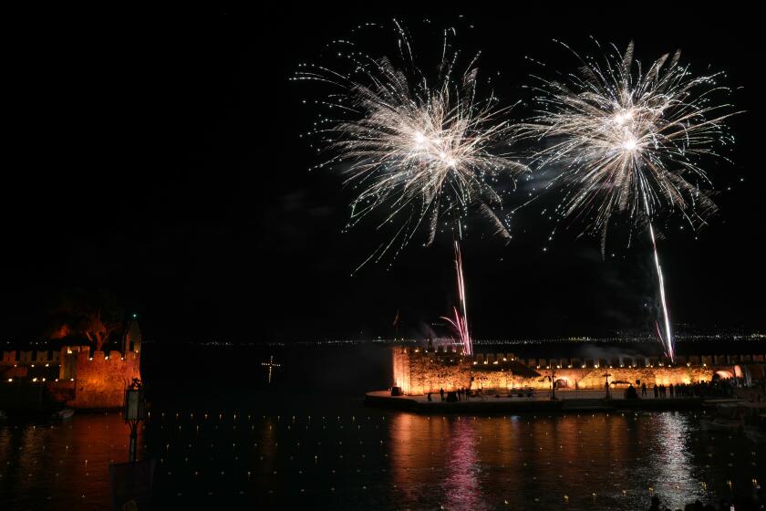 Fireworks explode over the Venetian port after the procession of "Epitaphios", the bier that carries the body of Jesus Christ to his grave, in Nafpaktos town, western Greece, on Good Friday, May 3, 2024. The solemn processions in Greece, with the flower-adorned biers followed by the clergy and the faithful, are often spectacular, especially in places where bier processions from each parish converge into a central square. (AP Photo/Thanassis Stavrakis)