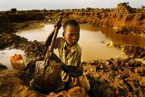 Six-year-old Buhari Ibrahim, whose father was killed by pro-government militiamen in Sudan, tries to help in a brick-making operation at Abu Shouk, but lifting the mud-filled shovel is a struggle. Experts fear another disaster is looming in the country's Darfur region, where the humanitarian crisis brought on by fighting is depleting already-scarce natural resources.