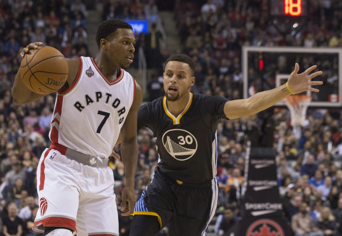 Toronto Raptors guard Kyle Lowry looks to make a pass as Golden State Warriors guard Stephen Curry defends during the first half of a game on Dec. 5.