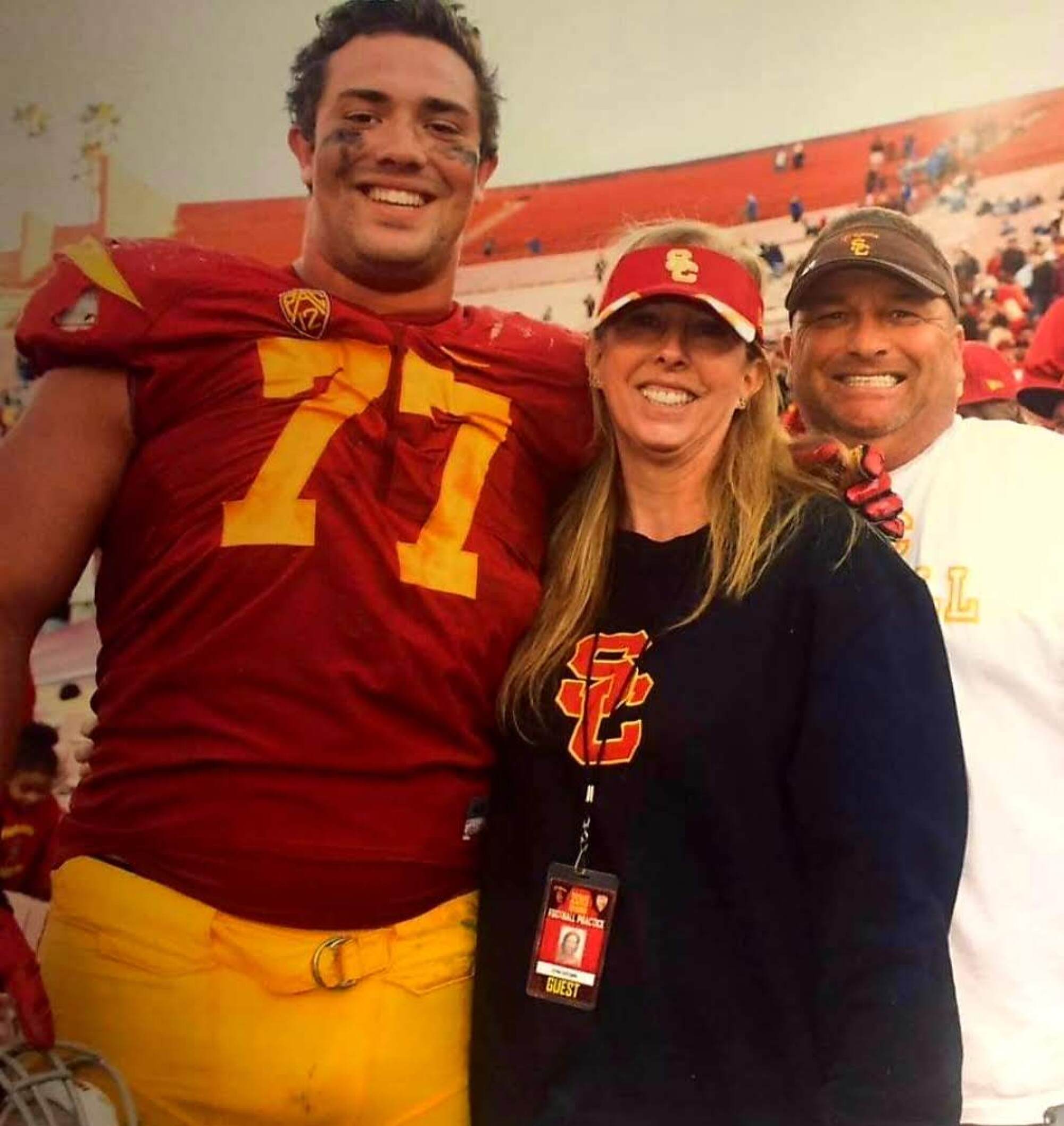 Chris Brown in a football uniform with mother Erin and father Bob
