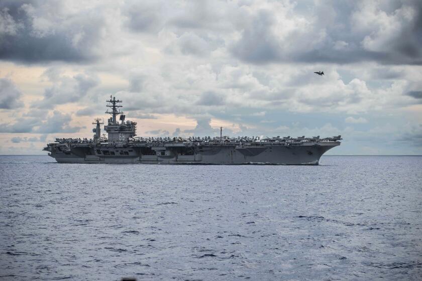 In this photo provided by U.S. Navy, USS Nimitz (CVN 68) steams alongside the Navy's only forward-deployed aircraft carrier USS Ronald Reagan (CVN 76, not in photo) in the South China Sea, Monday, July 6, 2020. China on Monday, July 6, accused the U.S. of flexing its military muscles in the South China Sea by conducting joint exercises with two U.S. aircraft carrier groups in the strategic waterway.(Aviation Boatswain's Mate (Handling) 3rd Class Kimani J. Wint/U.S. Navy via AP)