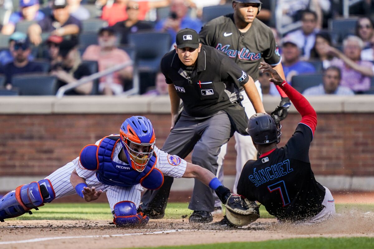 New York Mets catcher James McCann (33) tags out Miami Marlins' Jesus Sanchez (7) at home in the sixth inning of a baseball game, Saturday, July 9, 2022, in New York. (AP Photo/John Minchillo)