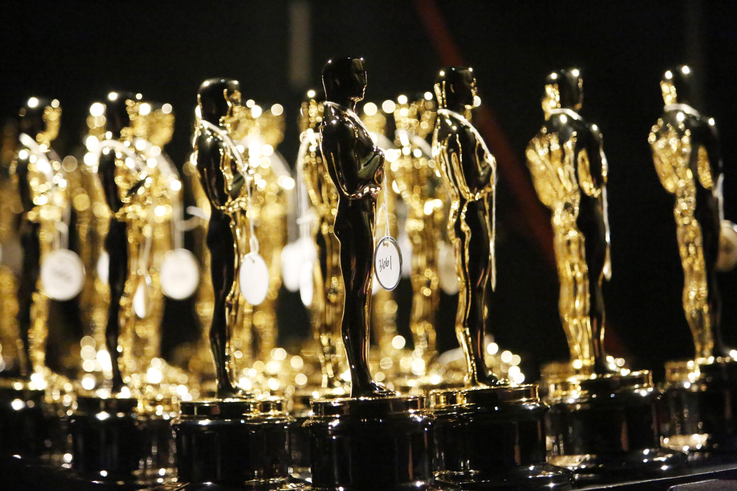 Oscar statuettes grouped backstage at a past Academy Awards ceremony.