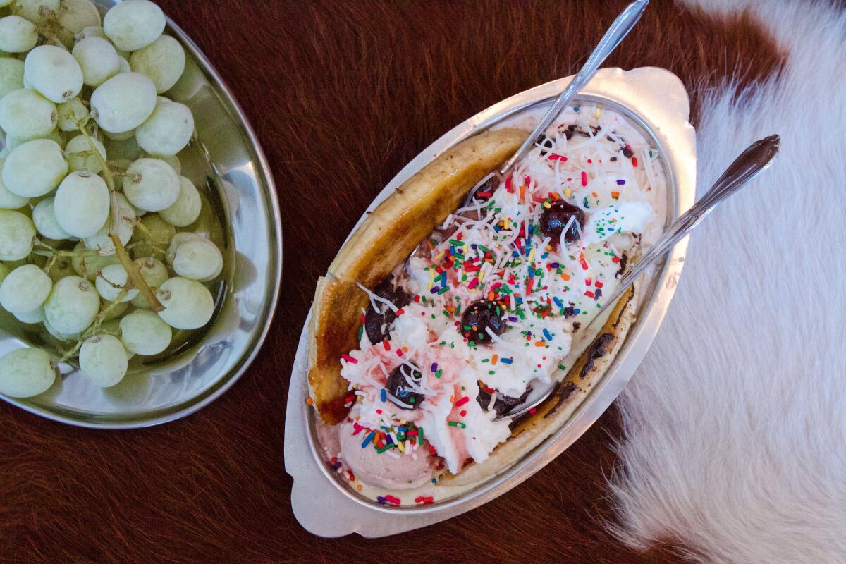 A brûléed banana split and platter of frozen grapes on a cowhide booth at Echo Park's Fluffy McCloud's 
