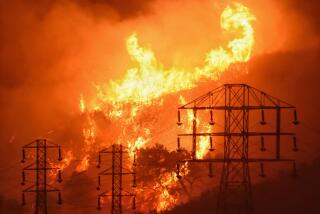 FILE - In this Dec. 16, 2017, file photo provided by the Santa Barbara County Fire Department, flames burn near power lines in Sycamore Canyon near West Mountain Drive in Montecito, Calif. Pacific Gas & Electric has agreed to pay $11 billion to a group of insurance companies representing most of the claims from Northern California wildfires in 2017 and 2018 as the company tries to emerge from bankruptcy, the utility announced Friday, Sept. 13, 2019.(Mike Eliason/Santa Barbara County Fire Department via AP, File)