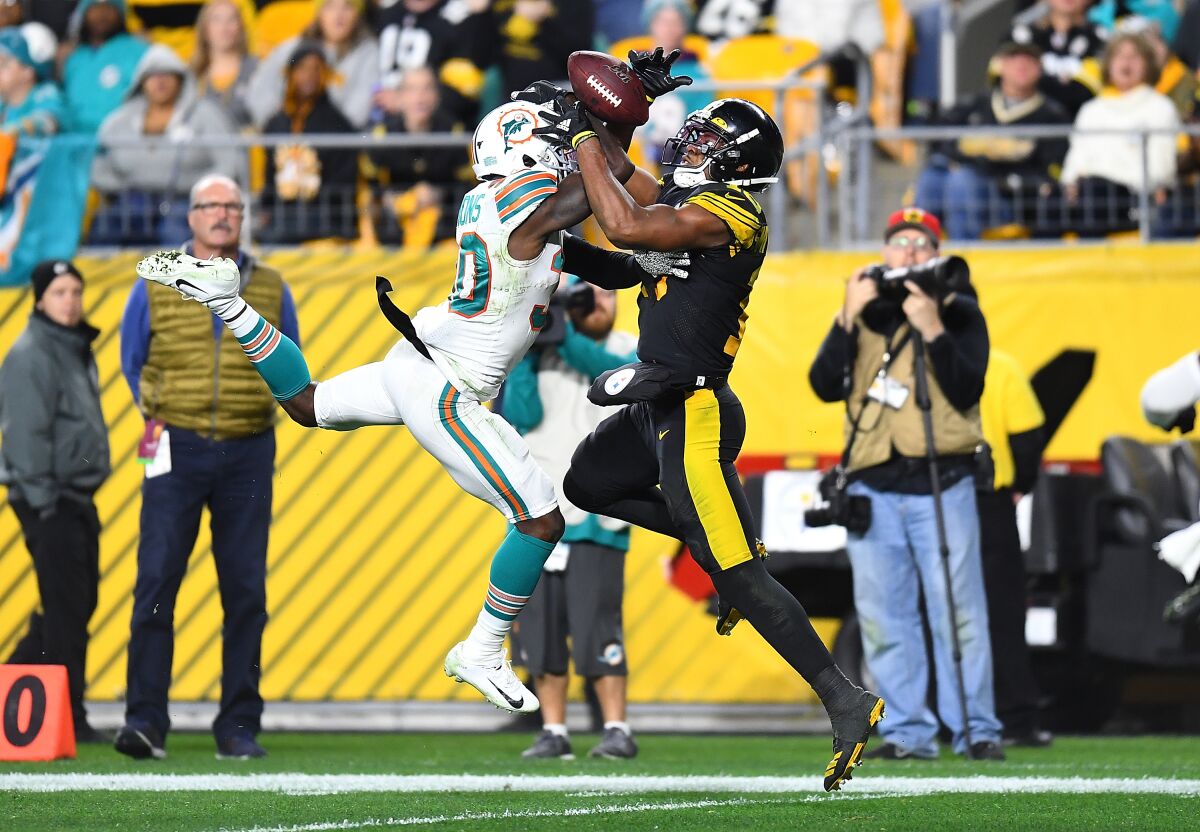 Pittsburgh Steelers wide receiver JuJu Smith-Schuster catches a pass in front of Miami Dolphins safety Chris Lammons.