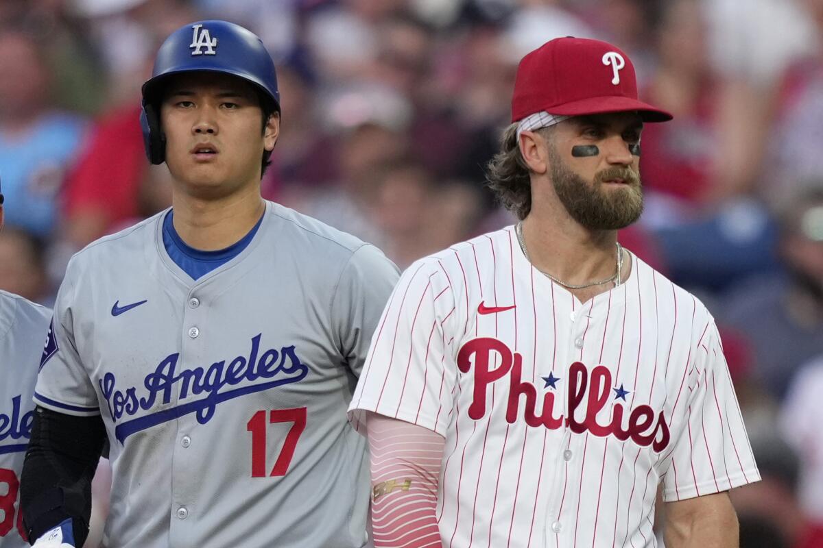 Shohei Ohtani, left, and Phillies star Bryce Harper stand next to one another.