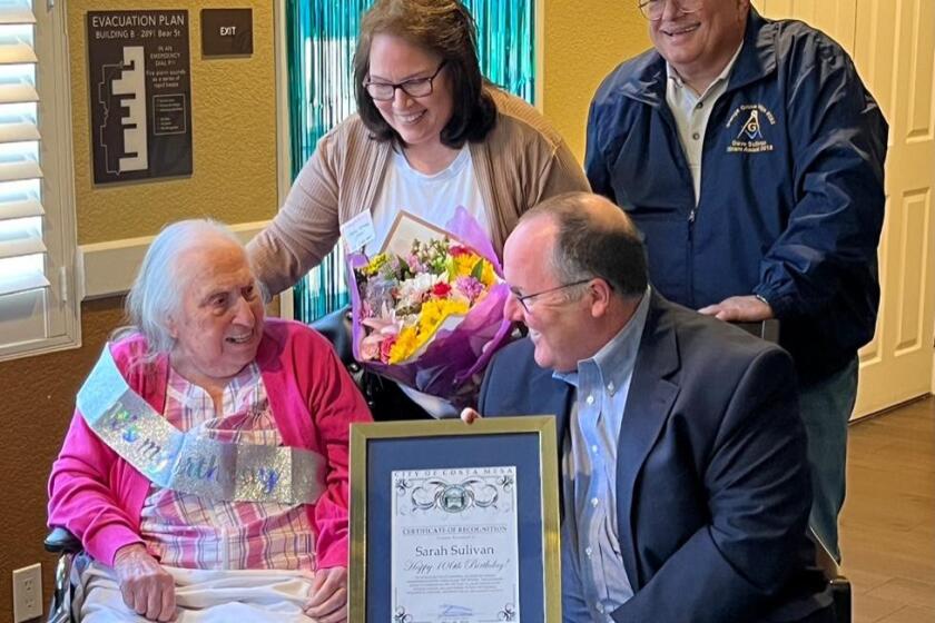 Costa Mesa Mayor, right, presents a proclamation to resident Sarah Sullivan on her 106th birthday as Sullivan's daughter, Paula, and son David Jr look on.