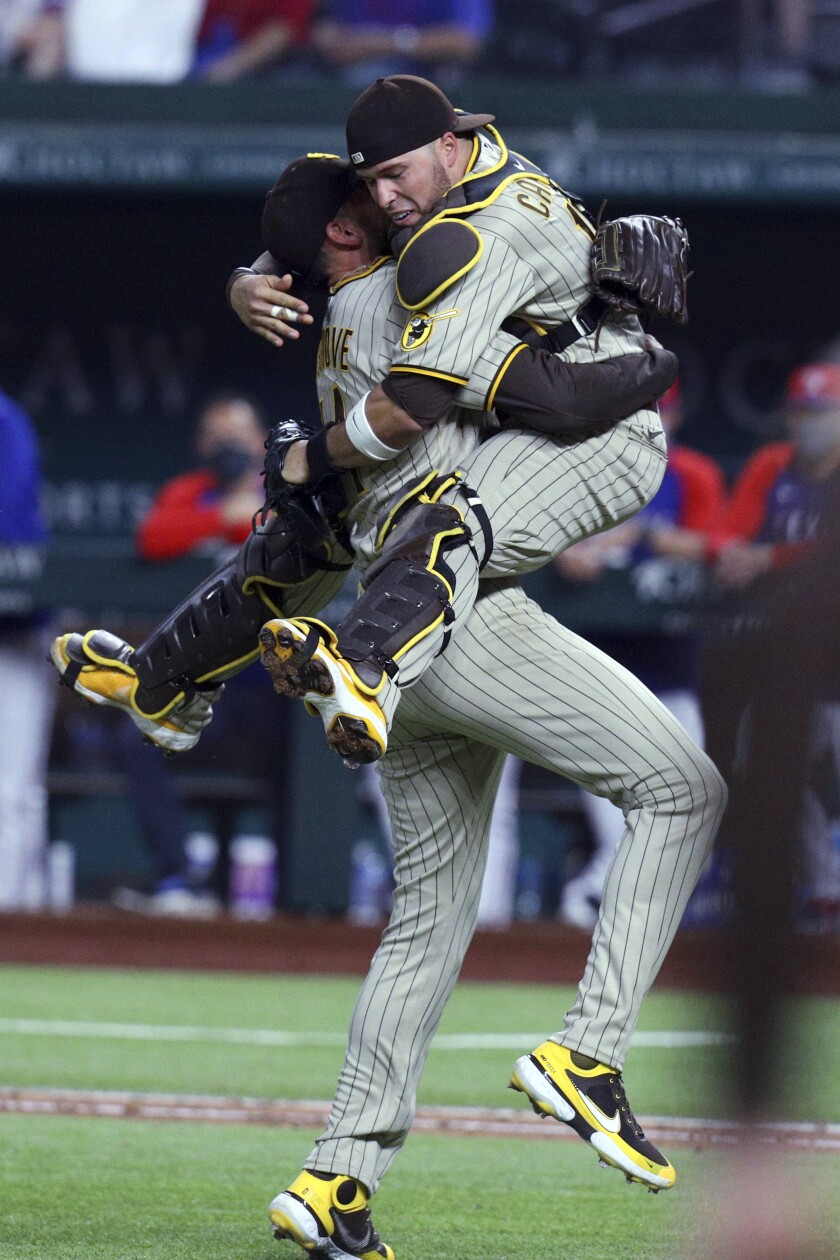 San Diego Padres starting pitcher Joe Musgrove (44) and catcher Victor Caratini (17) celebrate Musgrove's no-hitter against the Texas Rangers in a baseball game Friday, April 9, 2021, in Arlington, Texas. (AP Photo/Richard W. Rodriguez)