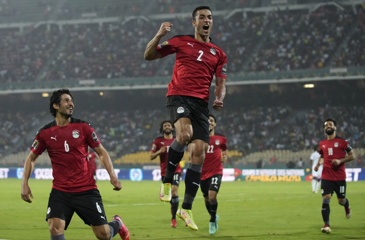 Egypt's Mohamed Abdel-Moneim, middle, jumps as he celebrates with teammates after scoring his team's first goal, during the African Cup of Nations 2022 group D soccer match between Egypt and Sudan at the Ahmadou Ahidjo stadium in Yaounde, Cameroon, Wednesday, Jan. 19, 2022. (AP Photo/Themba Hadebe)