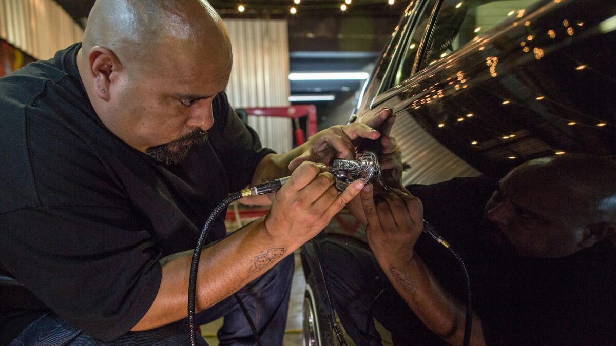 Jose Jesus engraves a door handle during a gathering of lowrider enthusiasts in Sao Paulo, Brazil.