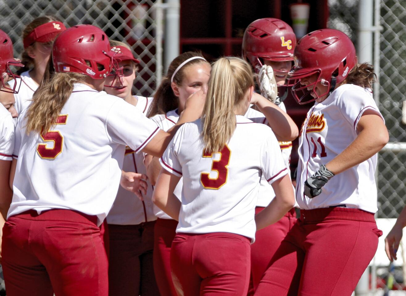 La Cañada High School softball player #11 Gillian Arnold is congratulated by her teammates after she hit a monster home-run in home game vs. San Marino High School, in La Cañada Flintridge on Friday, April 15, 2016. LCHS won the game in 5 innings 16-0.