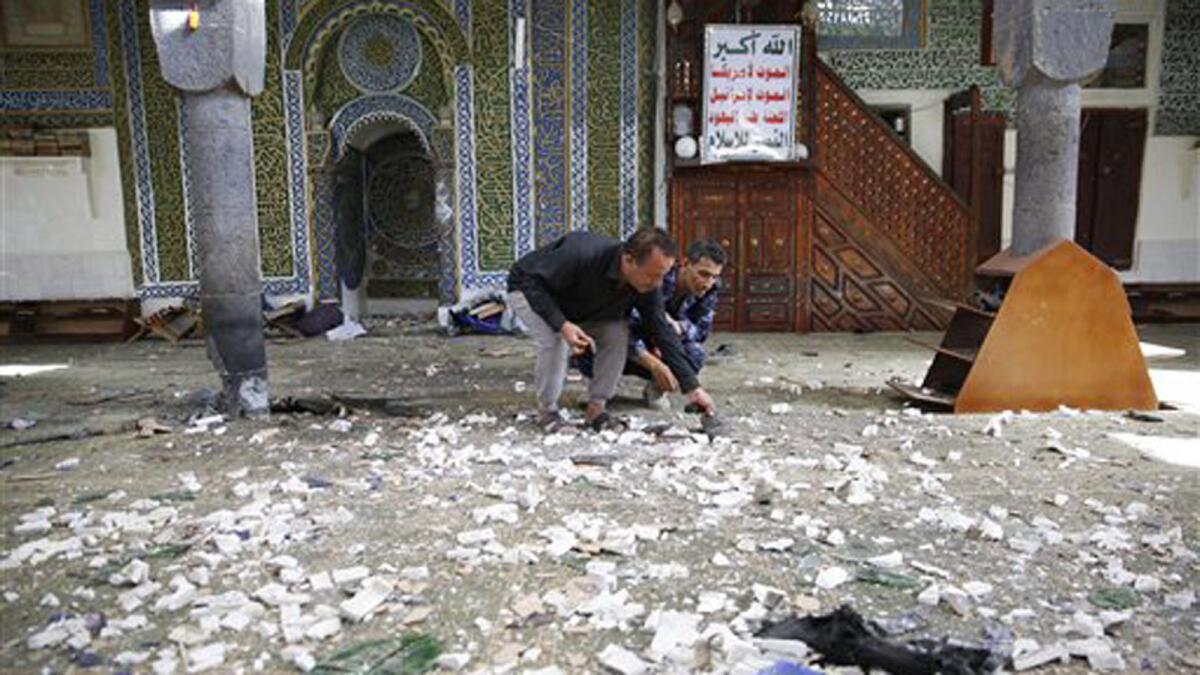 Police inspect the interior of the Balili mosque in Sana, Yemen, after two bomb blasts.