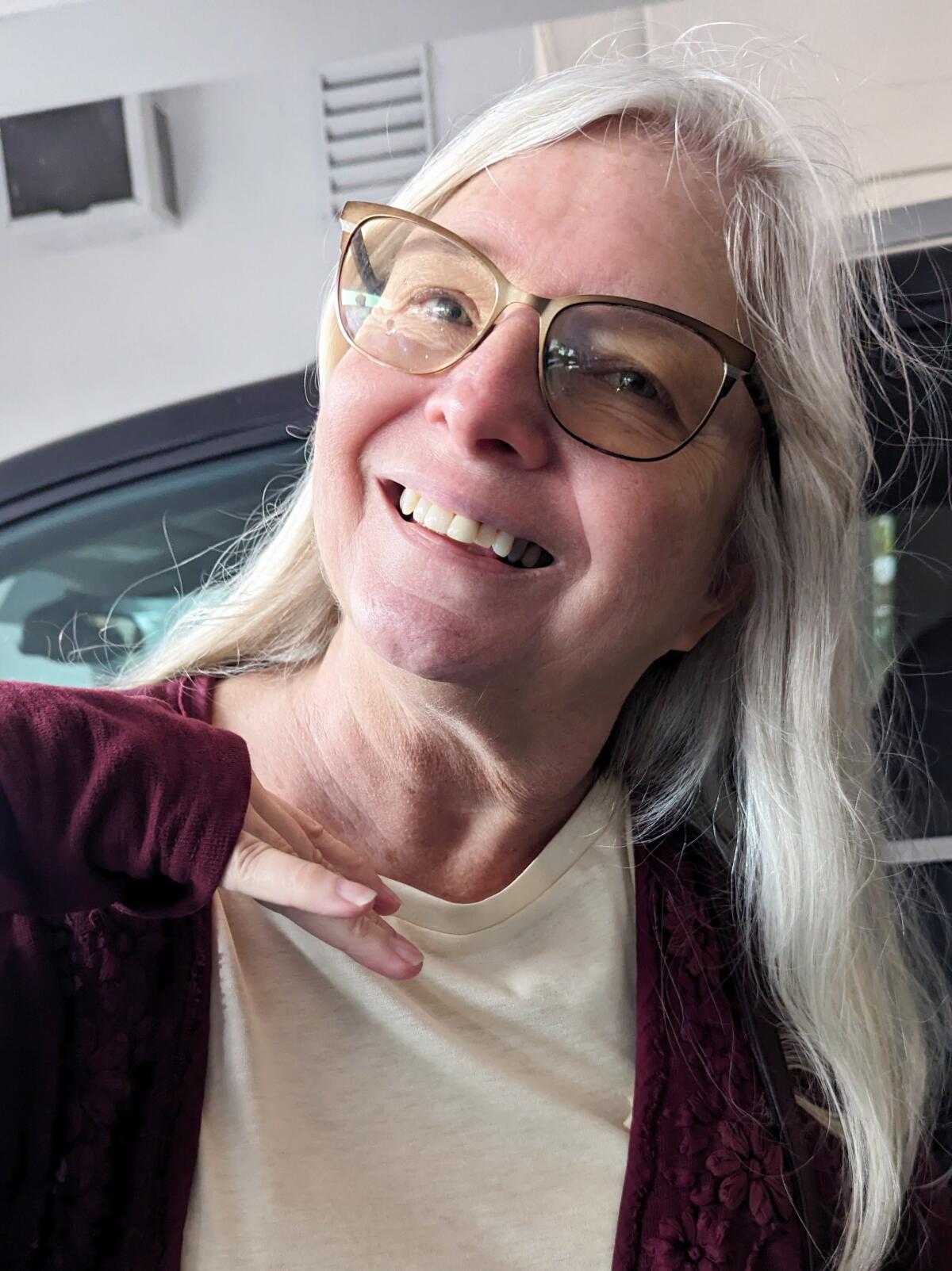Portrait of a smiling Suzanne Nunn in glasses.