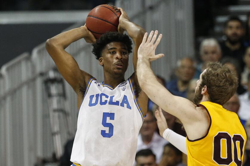 UCLA guard Chris Smith (5) passes against Arizona State forward Mickey Mitchell.