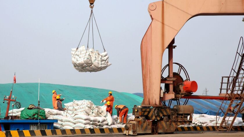 Chinese workers transfer bags of soybeans in March at a port in Nantong in China's eastern Jiangsu province. Simmering trade tensions between the world's top two economies are set to erupt into a full-blown trade war.