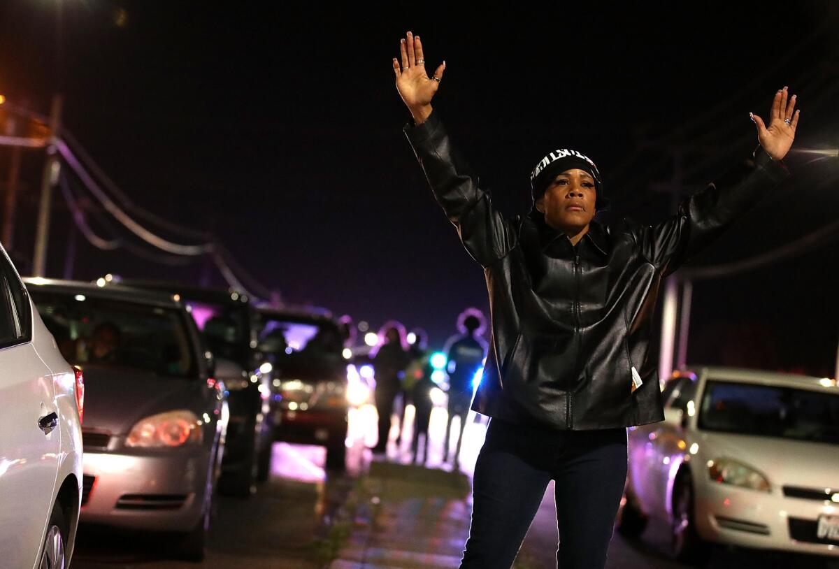 A Black Lives Matter protester holds her hands up during a demonstration Friday night as part of continuing protests over the shooting death of an unarmed black man by Sacramento police.