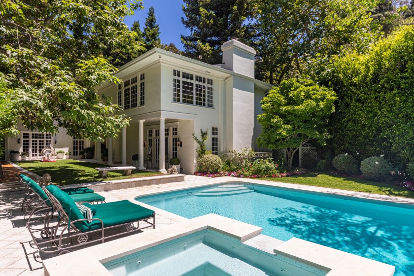 The house sits behind fences and hedges with a swimming pool and spa, expansive decking and a one-bedroom guesthouse.