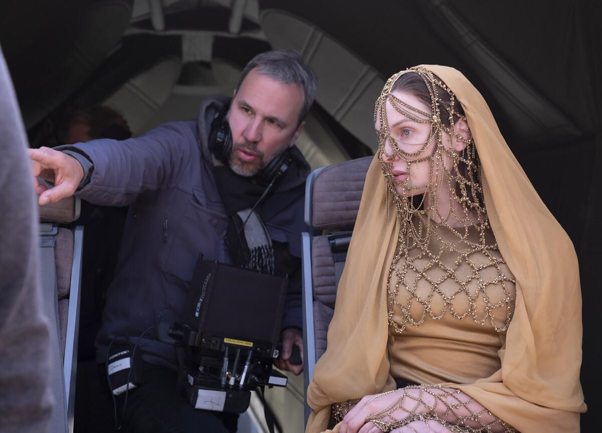 Denis Villeneuve pointing next to Rebecca Ferguson on the set of "Dune"
