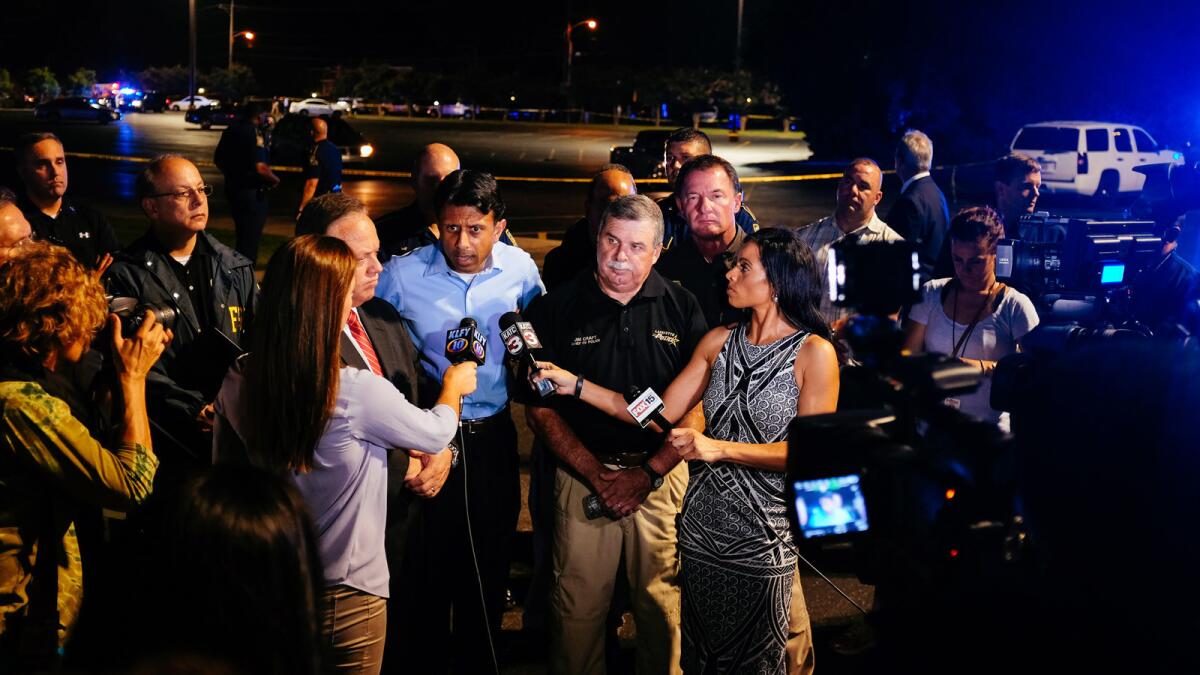 Louisiana Gov. Bobby Jindal, center, speaks with reporters after a deadly shooting at the Grand Theatre in Lafayette, La., on Thursday.