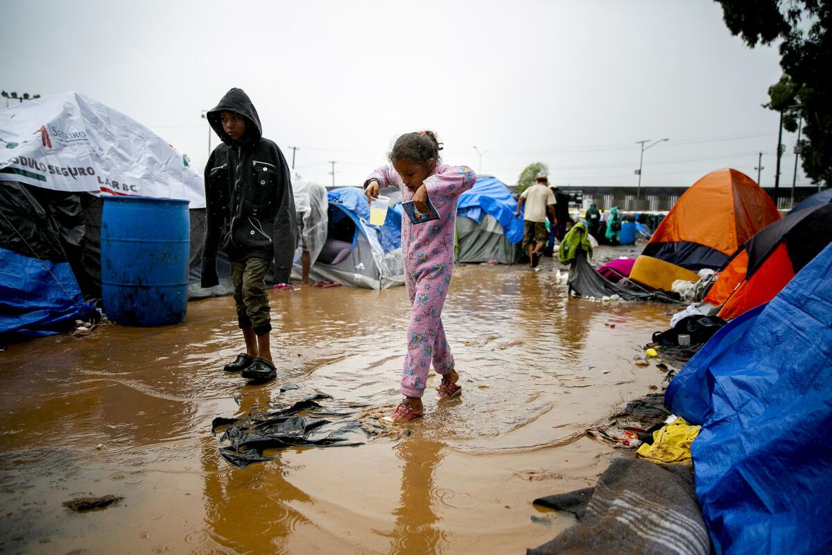 TIJUANA, MEXICO, November 29, 2018 | Seven-year-old Diosana Lopez of Honduras traverses a puddle inside the Benito Juarez sports complex, which is being used as a shelter, in Tijuana, Mexico. | PHOTO/SAM HODGSON Staff photographer, San Diego Union-Tribune. ©2018