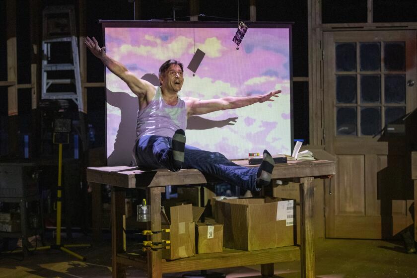 LOS ANGELES, CA - APRIL 11, 2022: Baritone Nathan Gunn imitates flying while performing in the one-man opera "In Our Daughter's Eyes" at the REDCAT on April 11, 2022 in Los Angeles, California.(Gina Ferazzi / Los Angeles Times)