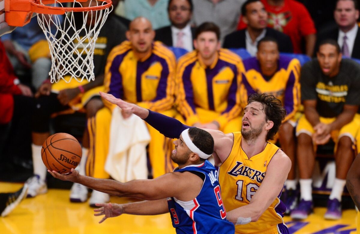 Clippers forward Jared Dudley, left, puts up a shot in front of Lakers forward Pau Gasol during each team's season opener in October. Dudley hasn't missed a game this season despite playing with tendinitis in his right knee.