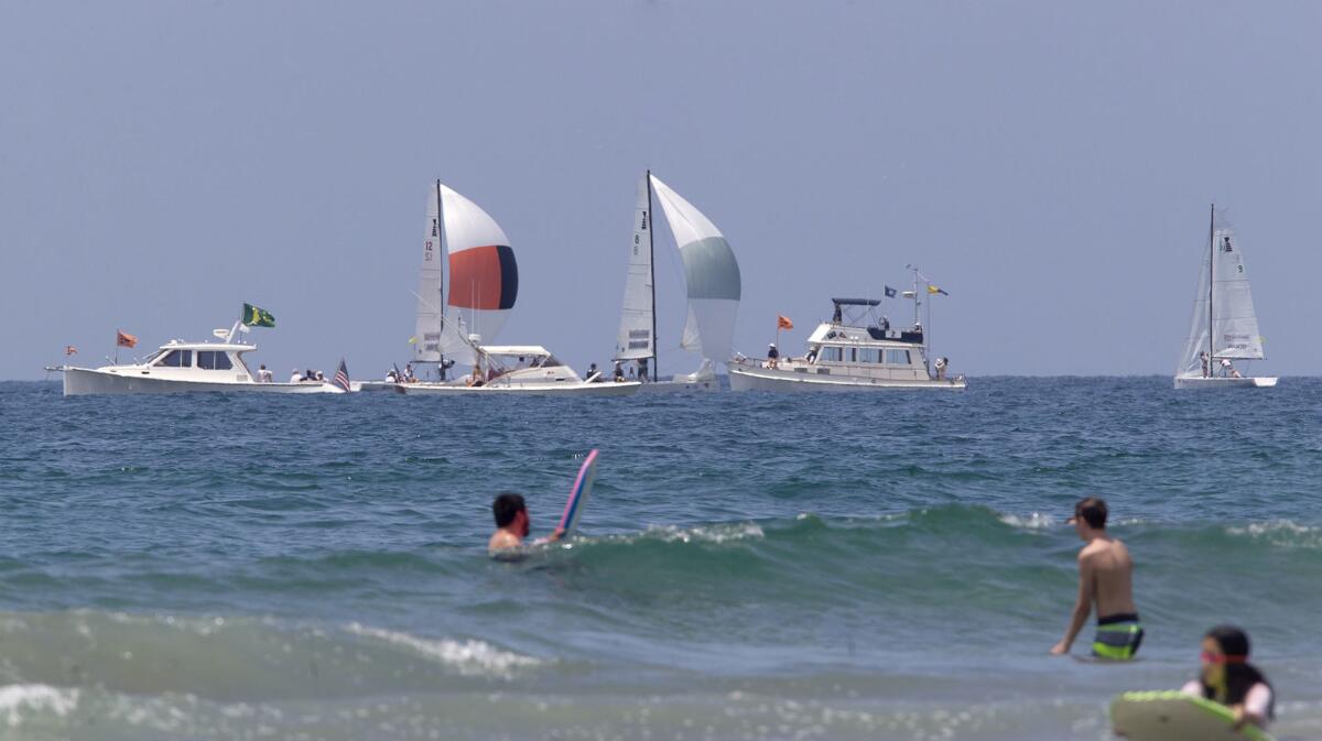 Boats sail along the coast, north of Newport Pier, during opening day for Balboa Yacht Club's Governor's Cup race in Newport Beach on Tuesday.