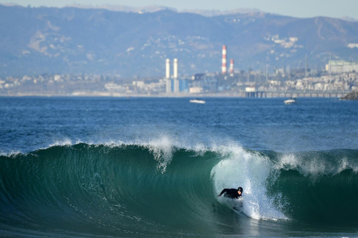 REDONDO BEACH, CALIFORNIA JANUARY 1, 2021-A surfer rides a wave on New Years Day in Redondo Beach Friday. (Los Angeles Times/Wally Skalij)
