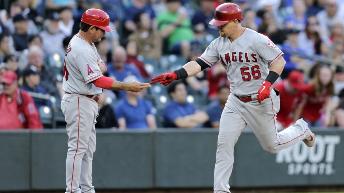 Angels' Kole Calhoun is congratulated by third base coach Mike Gallego after hitting a go-ahead two-run home off Seattle Mariners' Roenis Elias during the eighth inning on Saturday in Seattle.