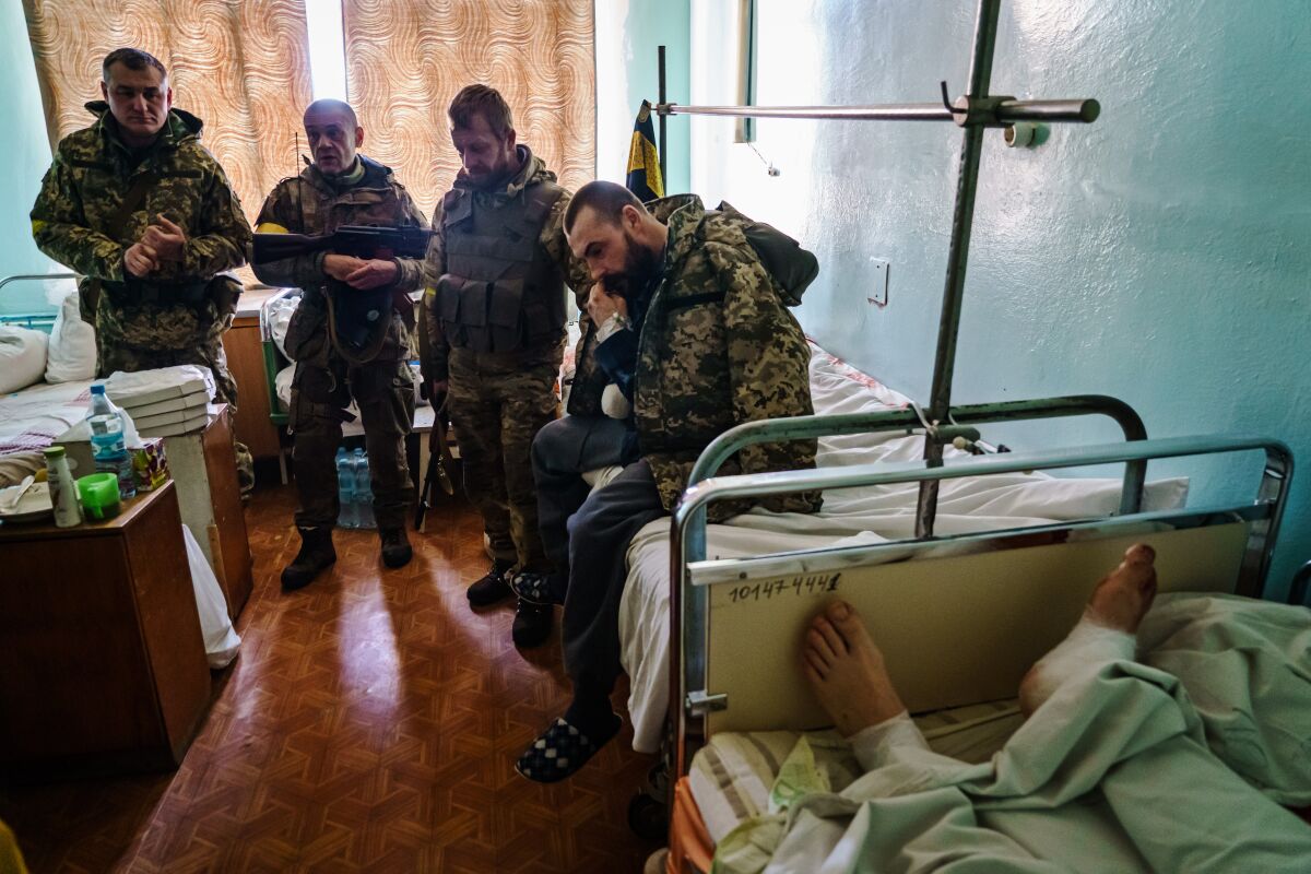 Soldiers stand in a Ukraine hospital room.