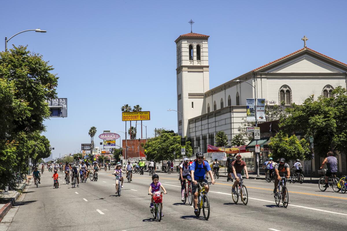 Dozens of bicyclists on a wide street empty of cars