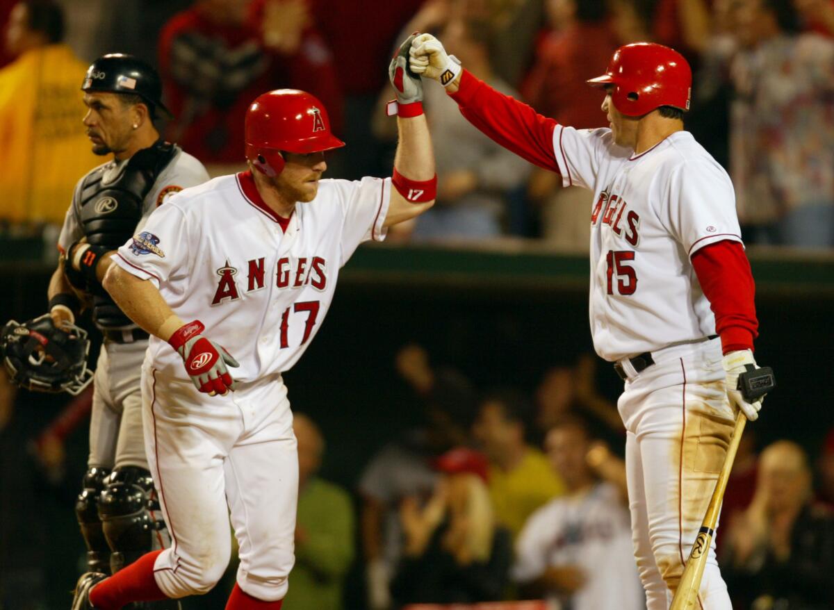 Darin Erstad, left, high-fives Tim Salmon after hitting a home run in the eighth inning of Game 6.