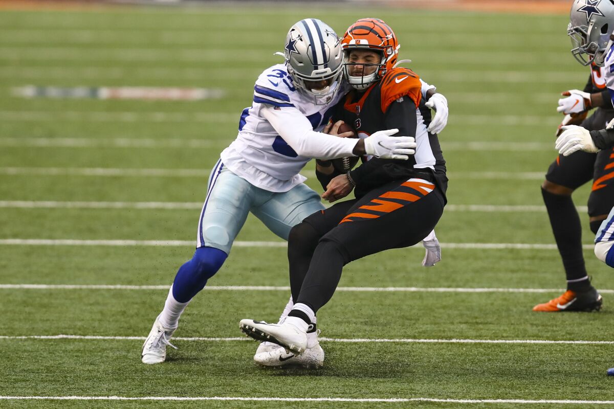 Dallas Cowboys defensive back Deante Burton (33) sacks Cincinnati Bengals quarterback Brandon Allen (8) in the second half of an NFL football game in Cincinnati, Sunday, Dec. 13, 2020. (AP Photo/Aaron Doster)