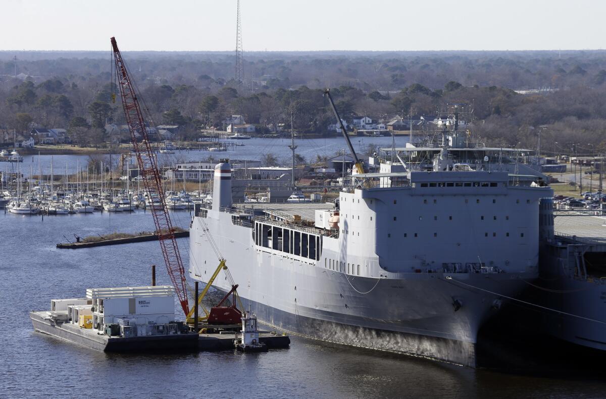 Workers in Portsmouth, Va., unload equipment Thursday from the Cape Ray, which will serve as the lynchpin for the international efforts to destroy Syria's chemical weapons. British officials announced Friday that their nation would destroy 165 tons of Syrian chemicals.